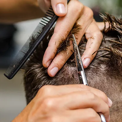 Un coiffeur coupe les cheveux d'un client avec des ciseaux et un peigne à Bourges dans le Cher 18